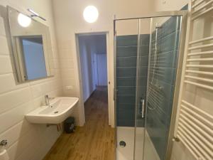 a bathroom with a sink and a glass shower at La Piazzetta 2 0 in LʼAquila