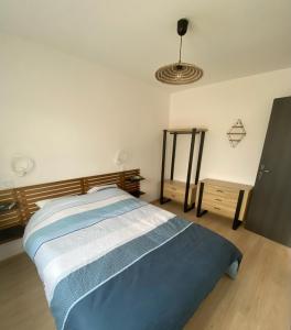 ein Schlafzimmer mit einem Bett mit einem Kopfteil aus Holz in der Unterkunft Parenthèse à la mer in Équihen-Plage