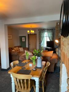 a dining room table with chairs and a living room at Bluebell Cottage Heritage Town nr Brecon Beacons with hot tub in Blaenavon