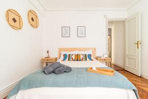 a bedroom with a large bed with blue blankets at Moderno apartamento en pleno centro in Santander