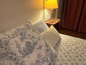 a bedroom with a bed with pillows and a lamp at Les Pommiers, Bouilland in Bouilland