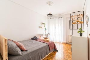 a white bedroom with a bed and a desk at Moderno apartamento en pleno centro in Santander