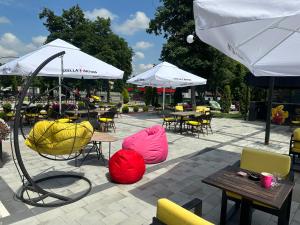 een terras met tafels, stoelen en parasols bij Hotel Cataleya in Šabac