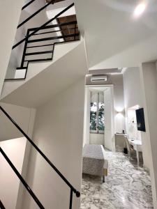 a white room with a staircase and a bedroom at MILUAR Luxury B&B - Vanvitelli in Naples