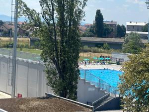 een groot zwembad met een boom op de voorgrond bij Hotel Cataleya in Šabac
