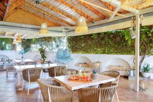a dining room with tables and chairs under awning at Villa Ioanna in Potos