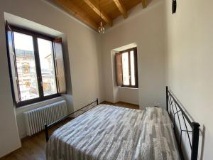 - une chambre avec un lit et 2 fenêtres dans l'établissement La Piazzetta 2 0, à LʼAquila