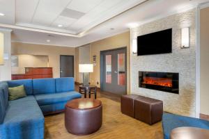 a living room with a blue couch and a fireplace at Comfort Inn & Suites in Blytheville