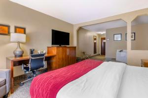 Habitación de hotel con cama, escritorio y TV. en Comfort Inn & Suites Christiansburg I-81, en Christiansburg
