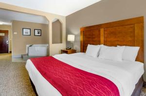 a hotel room with a large bed with a red blanket at Comfort Inn & Suites Christiansburg I-81 in Christiansburg
