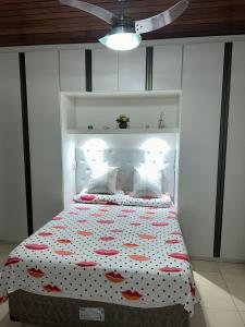 a bedroom with a bed with a polka dot bedspread at Quarto particular na praia do flamengo in Salvador