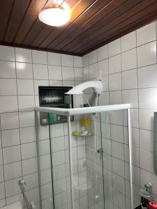 a bathroom with a shower with a glass shower stall at Quarto particular na praia do flamengo in Salvador