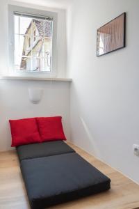 a black and red couch in a room with a window at Fortezza Ljubljana Center in Ljubljana