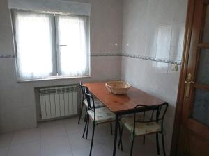 eine Küche mit Tisch und Stühlen und einem Fenster in der Unterkunft Vivienda Vacacional Alba Marinas in Pravia + 15 Fotos