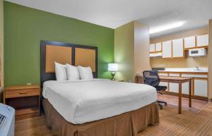 a bedroom with a large bed and a kitchen at Extended Stay America Suites - Indianapolis - Northwest - College Park in Indianapolis