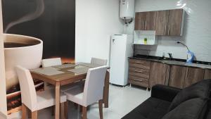 uma cozinha com uma mesa e cadeiras e um frigorífico em Departamento moderno con pileta em Puerto Iguazú