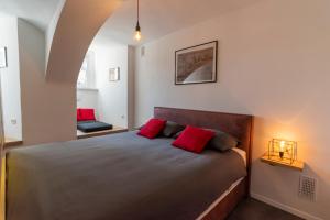 a bedroom with a large bed with red pillows at Fortezza Ljubljana Center in Ljubljana