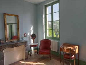 um quarto com uma lareira, um espelho e uma cadeira em 1812 Route de Baziège à Labège em Labège