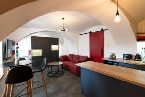 a kitchen and living room with a red couch at Fortezza Ljubljana Center in Ljubljana