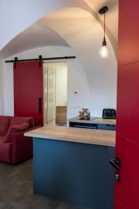 a kitchen with a counter and a red couch at Fortezza Ljubljana Center in Ljubljana