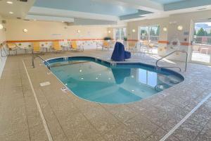 a pool in the middle of a room with tables and chairs at Comfort Inn & Suites Akron South in Akron
