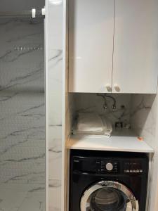 cocina con lavadora bajo un armario en Alliance apartments in Batumi sea view, en Batumi