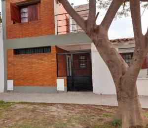 budynek z drzewem przed nim w obiekcie Casa cercana al Estadio Madre de Ciudades w mieście Santiago del Estero