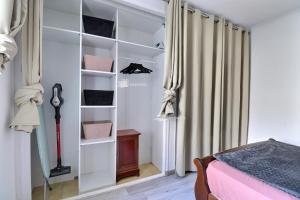 a bedroom with a closet with white shelves and a bed at T2 de 40 m2 avec jacuzzi au pied du massif in Marseille