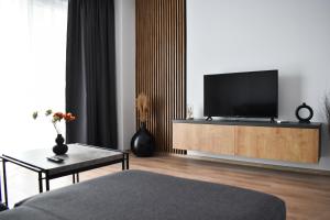 a living room with a flat screen tv on a cabinet at Sunset view Armoniei Apartament in Timişoara
