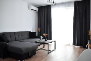 un salon avec un canapé et une table dans l'établissement Sunset view Armoniei Apartament, à Timişoara