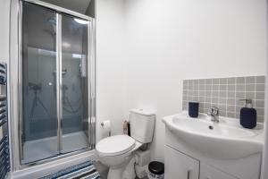 a bathroom with a toilet and a sink and a shower at Stylish Suite with free parking in Manchester
