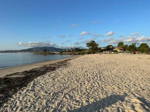 una playa con huellas en la arena y el agua en Baiona-Mar, gastronomía y cultura, en Baiona