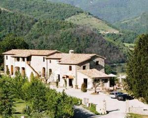 a large white house with mountains in the background at Villa Valentina Spa in Umbertide