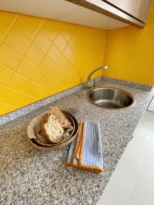 un mostrador con un plato de pan y un fregadero en Malpica diseño, en Malpica de Bergantiños