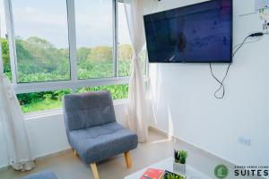 sala de estar con silla y TV de pantalla plana en Sierra Verde Living, en Apartadó