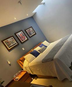 a bedroom with a bed and pictures on the wall at Casa La Vikina in Guanajuato
