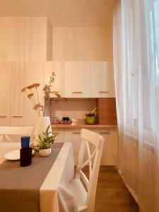 uma cozinha com uma mesa e armários brancos e uma mesa e cadeiras em Casa Oscar: Entire apartment Venice.Mestre station em Mestre