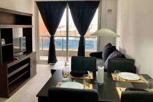 a living room with a table and chairs and a couch at 5-Súper Dpto en Morón centro in Morón
