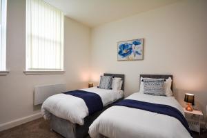 two beds sitting next to each other in a bedroom at Stylish Suite with free parking in Manchester