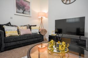 a living room with a couch and a tv at Stylish Suite with free parking in Manchester