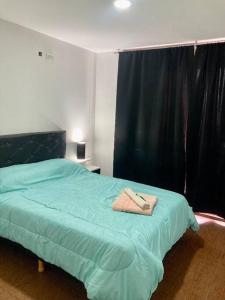 Un dormitorio con una cama con una toalla. en 5-Súper Dpto en Morón centro en Morón