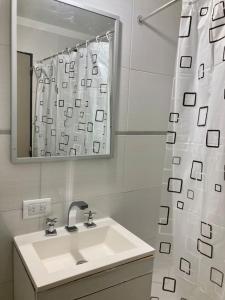 a white bathroom with a sink and a mirror at 5-Súper Dpto en Morón centro in Morón