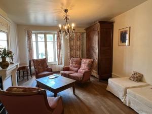 a living room with a couch and chairs and a table at Les Pommiers, Bouilland in Bouilland