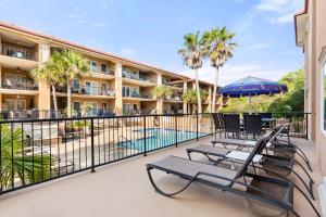 a balcony with chairs and a pool and a hotel at Brass Rail #105 in Tybee Island