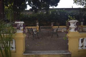 un grupo de sillas y bancos en un jardín en Hotel La Mansión, en Villarrica