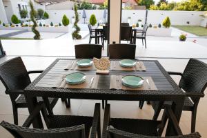 a black table with plates and napkins on a patio at Reshkov Pool Apartments in Gevgelija