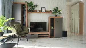 sala de estar con TV y silla en Prymasa Tysiąclecia 83A -E- dwa pokoje i garaż Perfect Apart en Varsovia