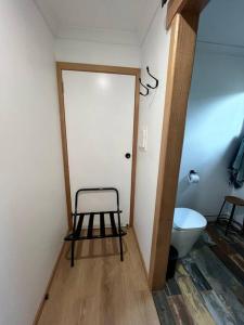 a bathroom with a toilet and a stool next to a door at Burnie Unit - The Cape in Burnie