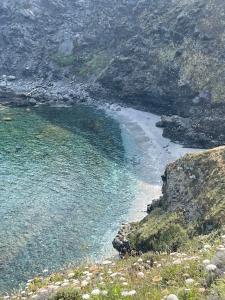 a view of a beach with rocks and water at La Mansarda in Biancareddu