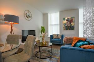 a living room with a blue couch and a table at Stylish One-bedroom with Free Parking Sleeps 4 in Manchester